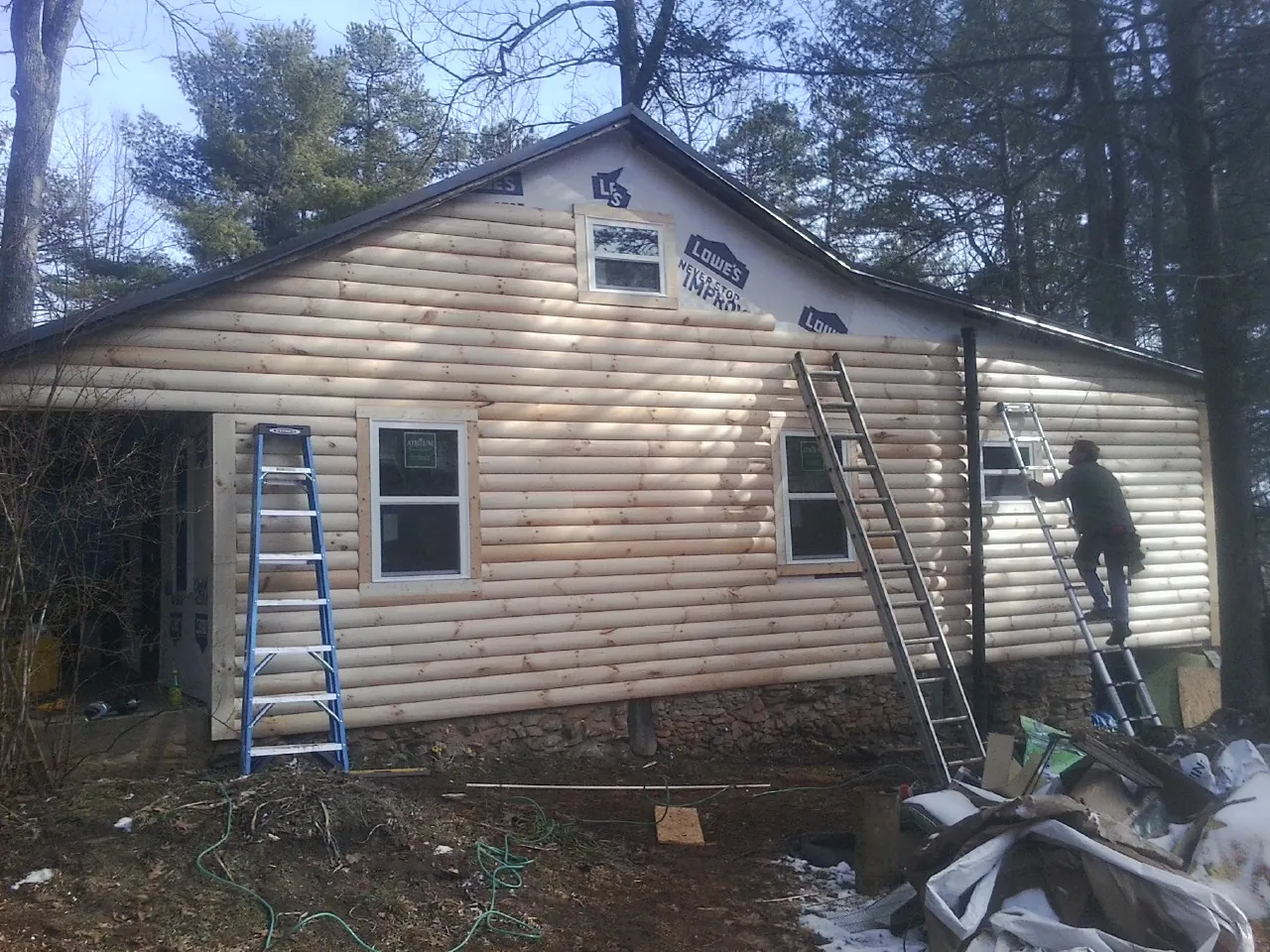 Ladders set against fresh log siding during an exterior remodel in Maryville