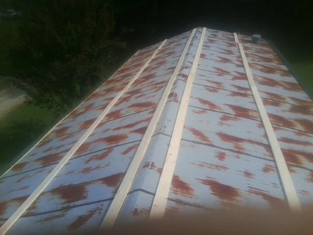 Rusted metal roof panels with new wood purlins before replacement — Storm Damage Roof Repair in Maryville by Roofing Brothers