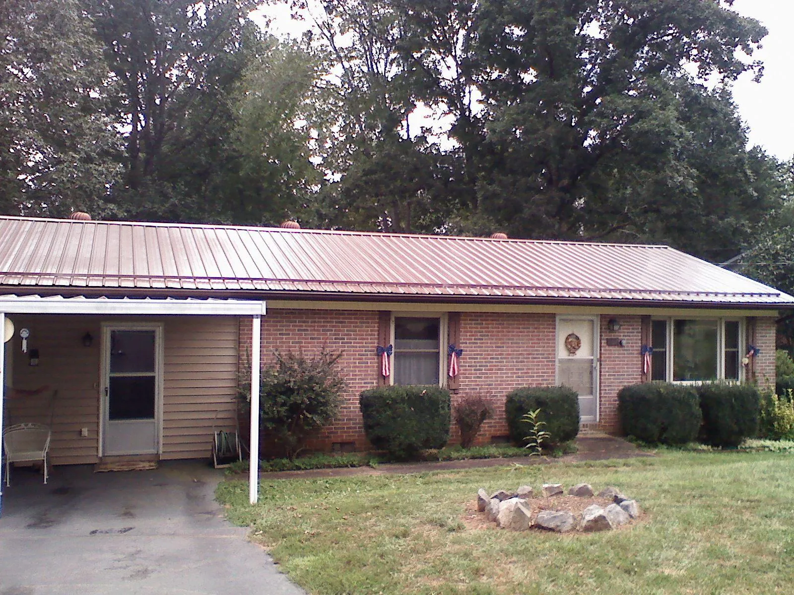 Bronze metal roof and carport on a brick ranch home — Roof Repair work by our crew in Maryville